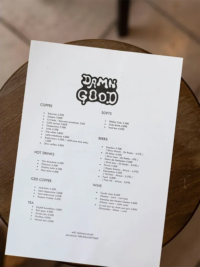 La carte des boissons imprimée, surmontée du lettrage bubble Damn Good, posée sur une table ronde
