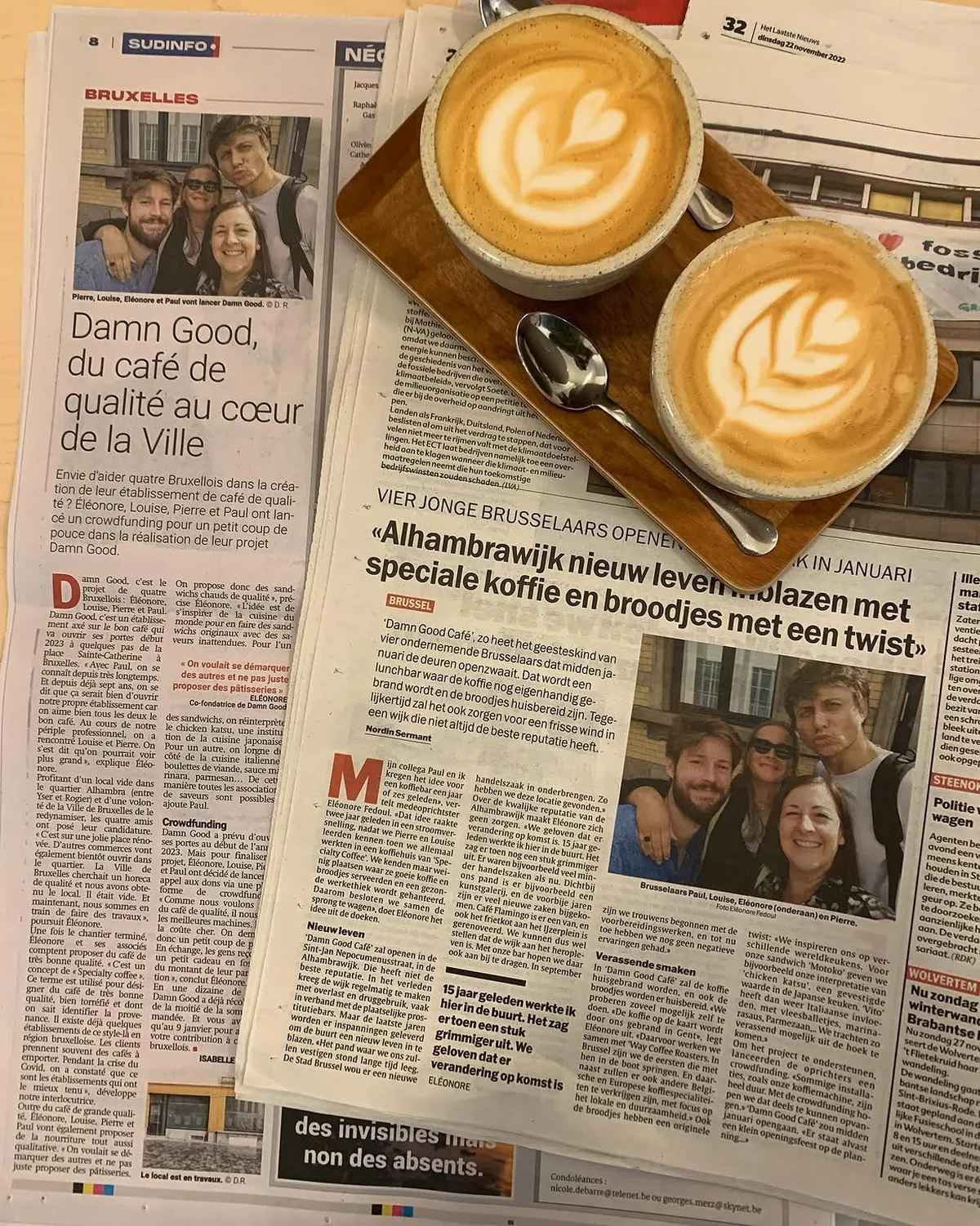 Deux cappuccinos posés sur des coupures de presse annonçant l'ouverture du Damn Good Café à Bruxelles