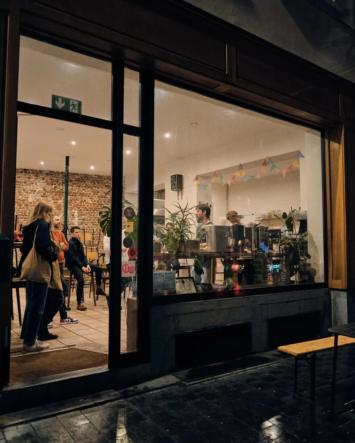 The lit storefront of Damn Good Café on a winter evening, Sint-Jan Nepomucenusstraat